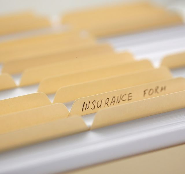 archivador de carpetas con la palabra insurance en una etiqueta